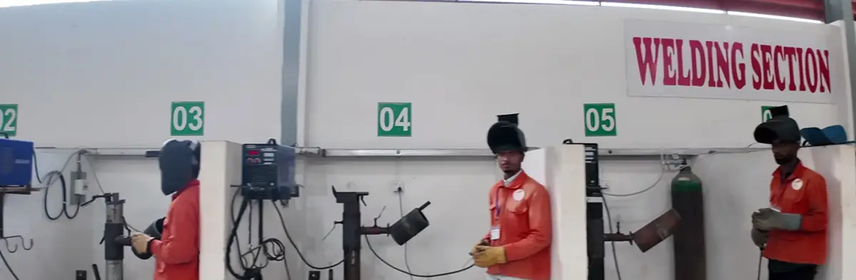 Welding section with numbered booths and trainees
